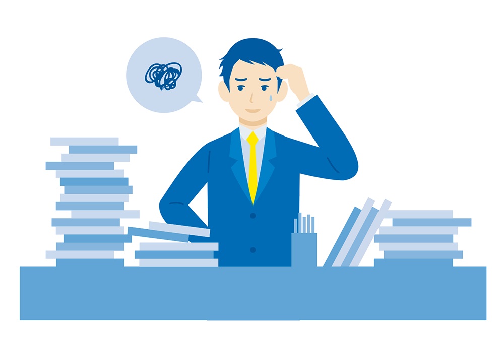 机の上が整理されていない様子に困っている人事担当者のイメージ